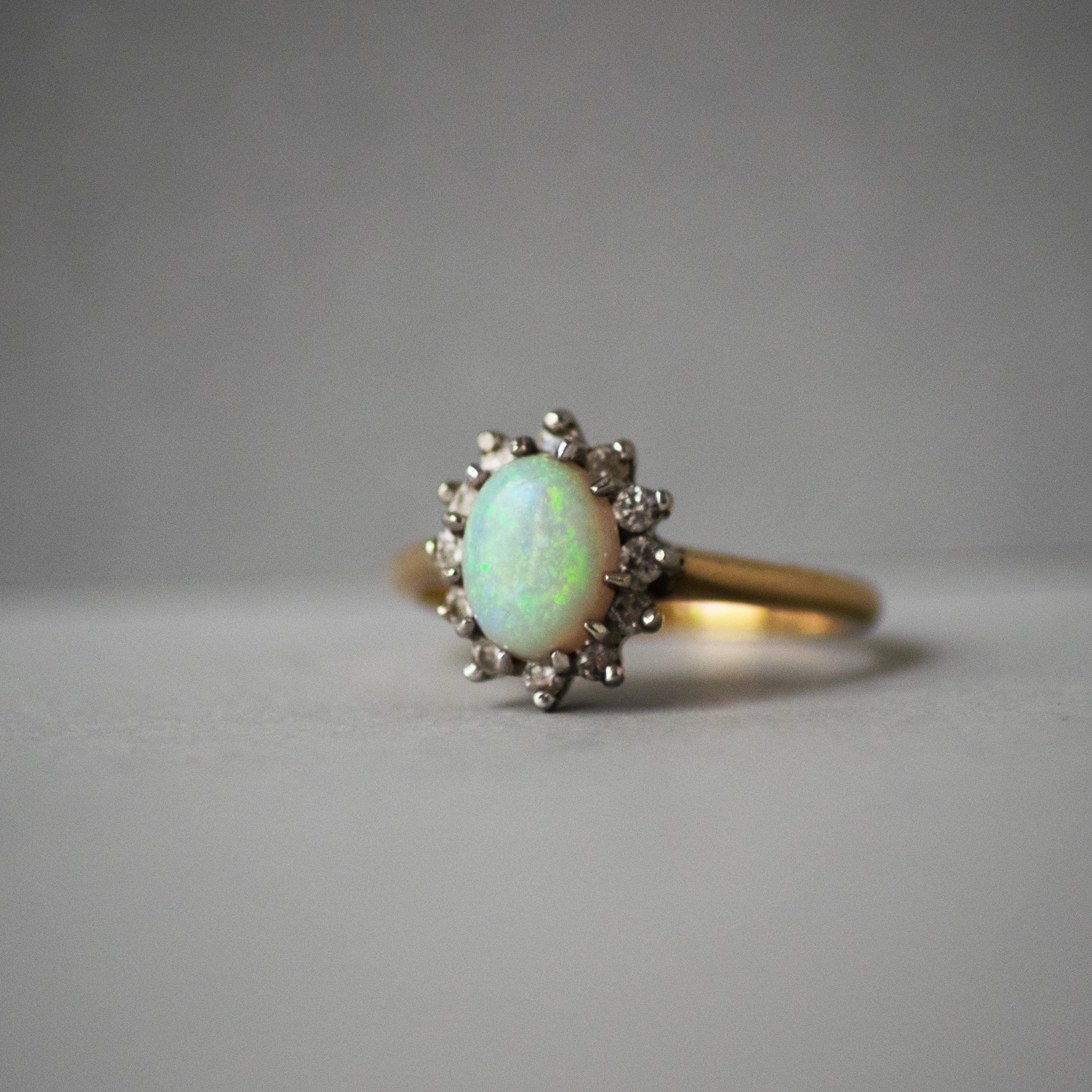 Gold ring with an opal stone on a gray background